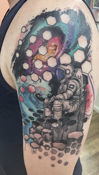 a tattoo of an astronaut on a thigh